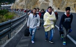 Venezuelans heading to Peru walk along the Panamerican highway in Tulcan, Ecuador, after crossing from Colombia, Aug. 21, 2018.