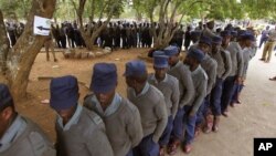 Zimbabwean police officers wait in line to cast their votes at a polling station in Harare, July 15, 2013. Early voting started for police and security personnel who will be on duty during the nation's July 31elections. 