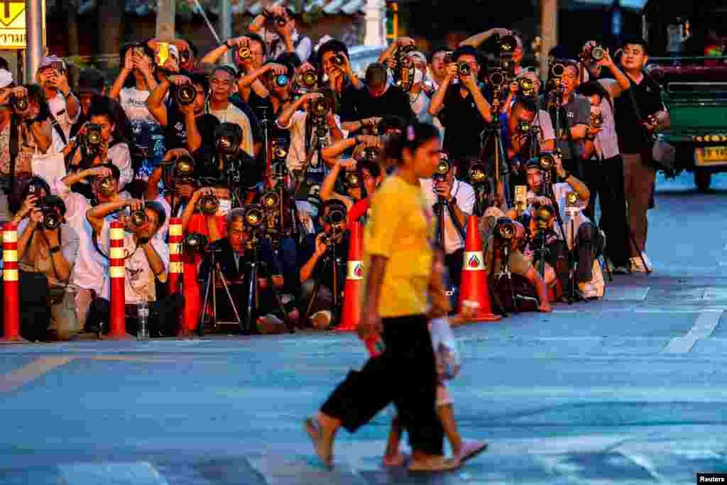 Orang-orang menyeberang jalan, saat fotografer mengambil gambar matahari terbenam di balik Ayunan Raksasa, juga dikenal sebagai Sao Chingcha, di Bangkok, Thailand. (Reuters)&nbsp;