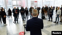 FILE - Members of the media listen as Peter Feldmann, mayor of the city of Frankfurt, speaks during his visit to a vaccination center as the coronavirus outbreak continues in Frankfurt, Germany, Dec. 17, 2020. 