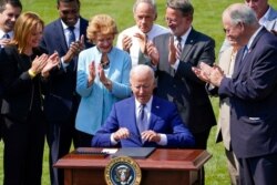 President Joe Biden signs an executive order on increasing production of electric vehicles after speaking on the South Lawn of the White House in Washington, Aug. 5, 2021.