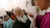 FILE - A priest gives communion host during a mass in a convent of Saint Germain en Laye, west of Paris.