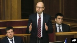 PM Arseniy Yatsenyuk (tengah) berhasil menghindari mosi tidak percaya terhadap dirinya di parlemen Ukraina hari Selasa (16/2).