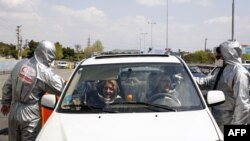 Members of the Iranian Red Crescent test people for coronavirus Covid-19 symptoms, as police blocked Tehran to Alborz highway to check every car outside Tehran on March 26, 2020.