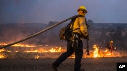 Los equipos de bomberos atienden una operación de quema a lo largo de la autopista 36 para frenar el incendio Park cerca de Dales, California, el lunes 29 de julio de 2024.