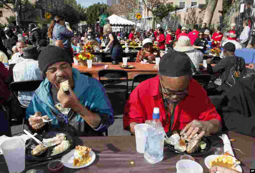 Michael Smith, left and Jerry Brown have their Thanksgiving meal with hundreds of homeless individuals, Los Angeles, California, November 21, 2012. 