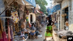 A woman walks through the Soubedioune craft market in Dakar, Senegal, Nov. 28, 2024.