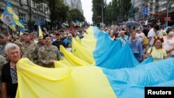 На фото: учасники Маршу захисників України у Києві з прапором, серпень 2020