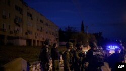 FILE - Israeli security forces stand in a neighborhood that was hit by a rocket fired from Lebanon, in Kiryat Shmona, northern Israel, January 11, 2024.