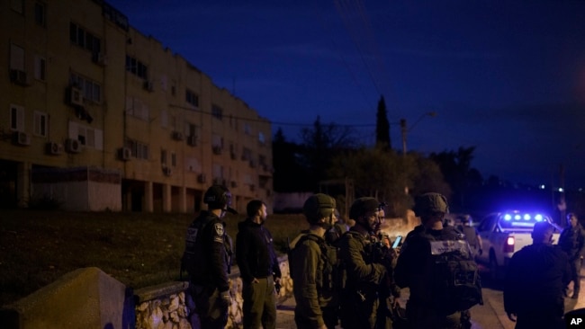 FILE - Israeli security forces stand in a neighborhood that was hit by a rocket fired from Lebanon, in Kiryat Shmona, northern Israel, January 11, 2024.