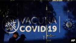 Un conductor pasa junto a un camión contenedor refrigerado del Ministerio de Salud que transporta dosis de vacunas COVID-19 que el gobierno de El Salvador donó a Honduras.