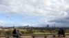 People sit on benches at Primrose Hill, in London, Sunday, March 29, 2020. The public have been asked to self isolate, keeping distant from others to limit the spread of the contagious COVID-19 coronavirus.