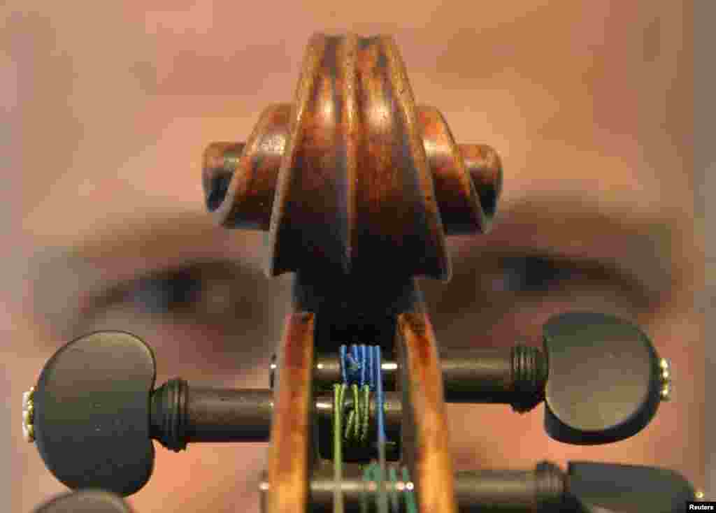 Kerry Keane, Christie&#39;s musical instruments specialist, poses for a photograph with the Kreutzer Stradivarius violin in London. The violin, estimated to be worth between $7.5 million (4.45 million pounds) and $10 million (5.9 million pounds), will be sold in New York on June 18.