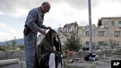 Un homme âgé bénéficie d’une assistance après l’effondrement des bâtiments suite à un tremblement de terre, en Amatrice, Italie, le 24 Août 2016. (AP Photo/Alessandra Tarantino)