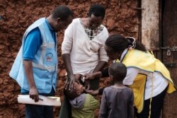 FILE - A boy receives drops of polio vaccine by a home-visit nurse in Kajiado, Kenya, July 11, 2018.