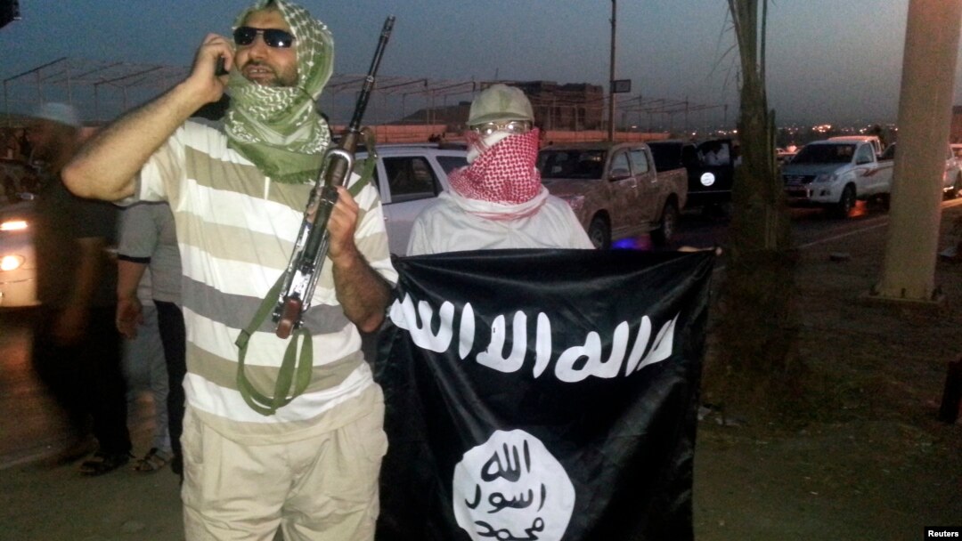 FILE - Militan ISIS memajang bendera kelompok tersebut di kota Mosul, Irak. 