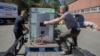 Henry Kovacs, left, and Hayden Wilson, right, volunteers with the Footprint Project, load two Tesla Powerwall batteries to deliver to communities impacted by Hurricane Helene in Mars Hill, N.C. on Oct. 9, 2024.