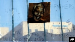 A print of Nelson Mandela and get-well messages hang outside of the Mediclinic Heart Hospital where former South African President Nelson Mandela is being treated in Pretoria, South Africa, June 24, 2013. 