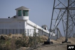 FILE - Watchtowers are seen on a high-security facility near what is believed to be a re-education camp where mostly Muslim ethnic minorities are detained, on the outskirts of Hotan, in China's northwestern Xinjiang region, May 30, 2019.