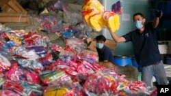 Workers unload counterfeit goods, mostly rubber slippers and sandals, for shredding at a customs-bonded warehouse at Cabuyao township, Laguna province southeast of Manila, Philippines, April 6, 2016. 