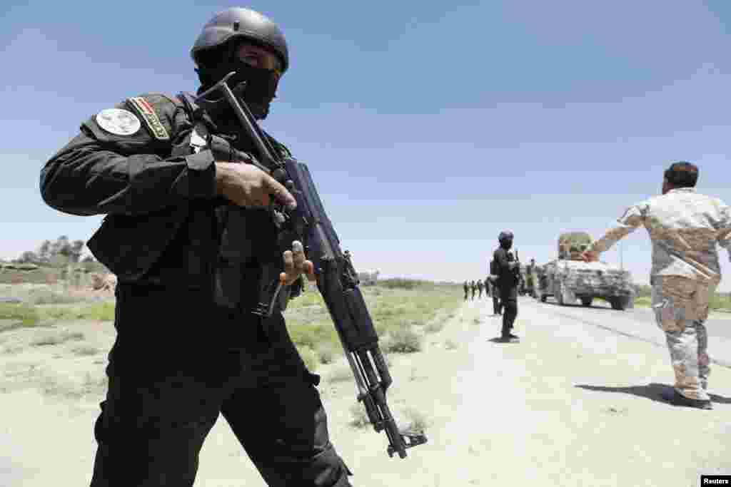 Members of the Iraqi security forces take their positions during an intensive security deployment west of Baghdad, June 24, 2014. 