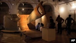 Workers stand around a giant saw installation that is cutting through a brick wall at the Partition Museum that is set to open in Amritsar, India, 32 kilometers (20 miles) from the border with Pakistan. The artistic installation depicts the division of India and tells the stories of those who survived the chaos and bloodshed seven decades ago.