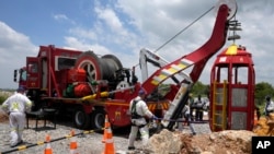 Rescue workers hoist up a cage that was used to rescue trapped people at an abandoned gold mine, in Stilfontein, South Africa, Jan. 16, 2025.