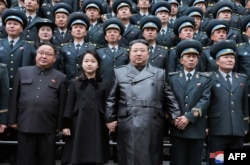 Північнокорейський лідер Кім Чен Ин разом із донькою та авіакосмічними науковцями позують після запуску супутника. 23 листопада 2023. KCNA VIA KNS / AFP