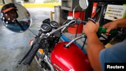 A man pumps gasoline at a service station in Caracas, Venezuela, Aug. 7, 2014.