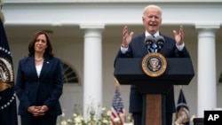 La vicepresidenta Kamala Harris escucha mientras el presidente Joe Biden habla sobre la orientación actualizada sobre los mandatos de las máscaras, en el Jardín de las Rosas de la Casa Blanca, el jueves 13 de mayo de 2021.