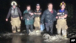 Rescue personnel bring stranded residents to shore in Montpelier, Vermont, August 28, 2011