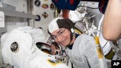 In this Aug. 17, 2021 photo astronaut and Expedition 65 Flight Engineer Mark Vande Hei inspects a spacesuit in preparation for a spacewalk. Nasa announced Aug. 23 it is delaying a spacewalk because of an undisclosed medical issue involving Vande Hei.