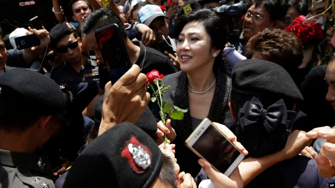 Mantan PM Thailand, Yingluck Shinawatra, tengah, menerima bunga dari pendukungnya di Mahkamah Agung setelah mengeluarkan pernyataan final dalam pengadilan atas tuduhan keteledoran kriminal di Bangkok, Thailand, 1 Agustus 2017 (foto: AP Photo/Sakchai Lalit)