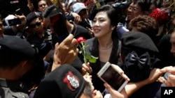 Mantan PM Thailand, Yingluck Shinawatra, tengah, menerima bunga dari pendukungnya di Mahkamah Agung setelah mengeluarkan pernyataan final dalam pengadilan atas tuduhan keteledoran kriminal di Bangkok, Thailand, 1 Agustus 2017 (foto: AP Photo/Sakchai Lalit)