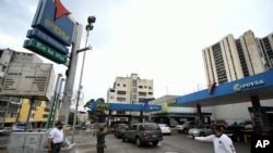 Un soldado hace guardia en una estación de servicio de la compañía petrolera estatal PDVSA donde los conductores esperan para llenar su tanque en Caracas, Venezuela. Mayo 25, 2020.