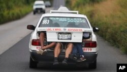 Central American migrants, part of the caravan hoping to reach the U.S. border, a ride on in the trunk of a taxi, in Acayucan, Veracruz state, Mexico, Nov. 3, 2018.