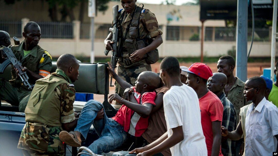 African Union Misca forces from Cameroon carry a wounded man as angry youth set up barricades throughout the town, May 29, 2014 in Bangui, Central African Republic. 