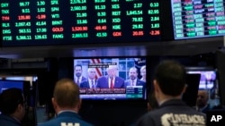 Traders listen at the New York Stock Exchange to President Donald Trump's televised speech from the White House, March 13, 2020, in New York.