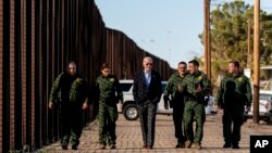 Джо Байден беседует с агентами пограничного патруля США, когда они прогуливаются вдоль участка американо-мексиканской границы в Эль-Пасо, штат Техас, 8 января 2023 года.