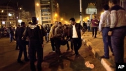 Protesters opposed to Egyptian President Mohammed Morsi evacuate and injured fellow protester during clashes between supporters of president Mohammed Morsi and their rivals in front of the president palace, in Cairo, Egypt, Wednesday, Dec. 5, 2012. 