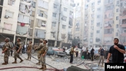 Personas y miembros del ejército inspeccionan el lugar de un ataque israelí en los suburbios del sur de Beirut, Líbano, el 20 de septiembre de 2024. 