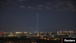 Ukrainian service personnel use searchlight as they search for drones in the sky over the city centre during a Russian drone strike, in Kyiv, Oct. 20, 2024.