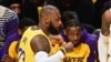 Los Angeles Lakers' guard Bronny James, center, watches father LeBron James in the NBA game season opener between the Lakers and the Minnesota Timberwolves at Crypto Arena in Los Angeles on October 22, 2024. They are the first father and son to play together in an NBA game. 