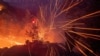 The wind whips embers while a firefighter battles the fire in the Angeles National Forest near Mt. Wilson as the wildfires burn in the Los Angeles area, during the Eaton fire in Altadena, California, Jan. 9, 2025. 