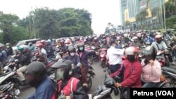 Pengendara sepeda motor yang berboncengan terpaksa harus balik arah dan tidak diperbolehkan masuk Surabaya pada hari pertama penerapan PSBB. (foto: VOA/ Petrus Riski)