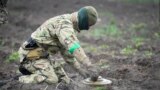 (FILE) An interior ministry sapper defuses a mine on a minefield after recent battles in Irpin close to Kyiv, Ukraine, on April 19, 2022.