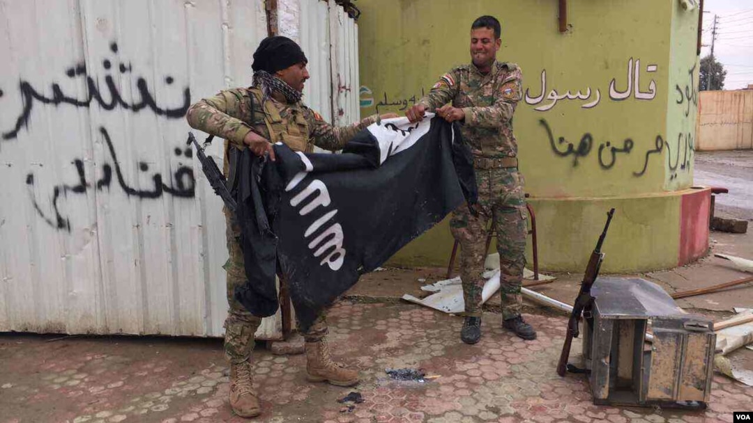 Dua tentara Irak merobek bendera ISIS di Mosul, Irak (foto: ilustrasi). Kelompok ekstremis ISIS terus kehilangan wilayah kekuasaannya di Irak dan Suriah. 