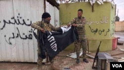 Two Iraqi forces tear IS flag. (Kawa Omar/VOA Kurdish)