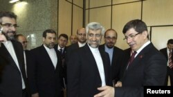 Turkiya tashqi ishlar vaziri Ahmet Davutoglu Eron rasmiysi Sayid Jaliliy bilan. 2012-yil, aprel. 