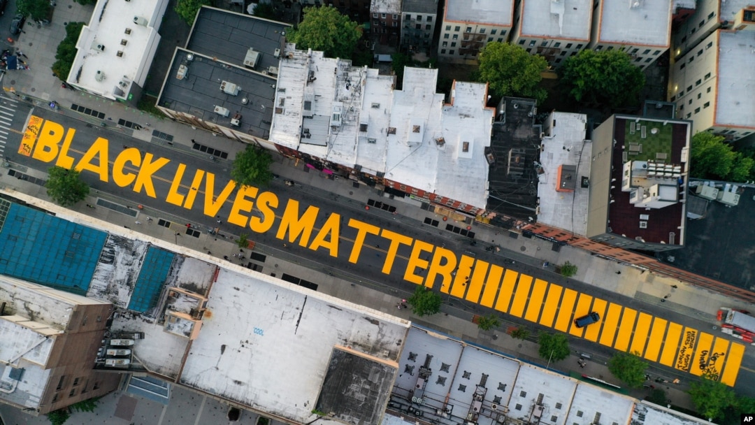 FILE - A giant "Black Lives Matter" sign is painted on Fulton Street, in the Brooklyn borough of New York City, June 15, 2020. 